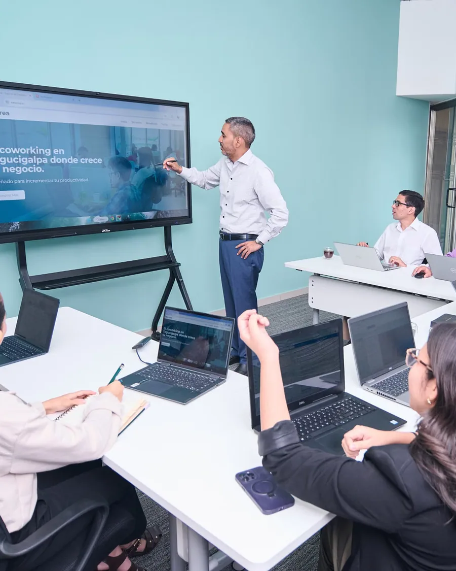 Un instructor enseña a un grupo frente a una pantalla, en un curso de inteligencia artificial colaborativo.